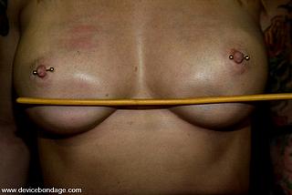 measuring the stroke of the cane on her vulnerable breasts