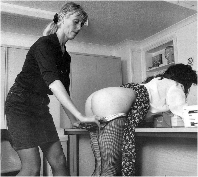 stern woman bends her secretary over a desk and rolls down her fishnet pantyhose before an office punishment caning