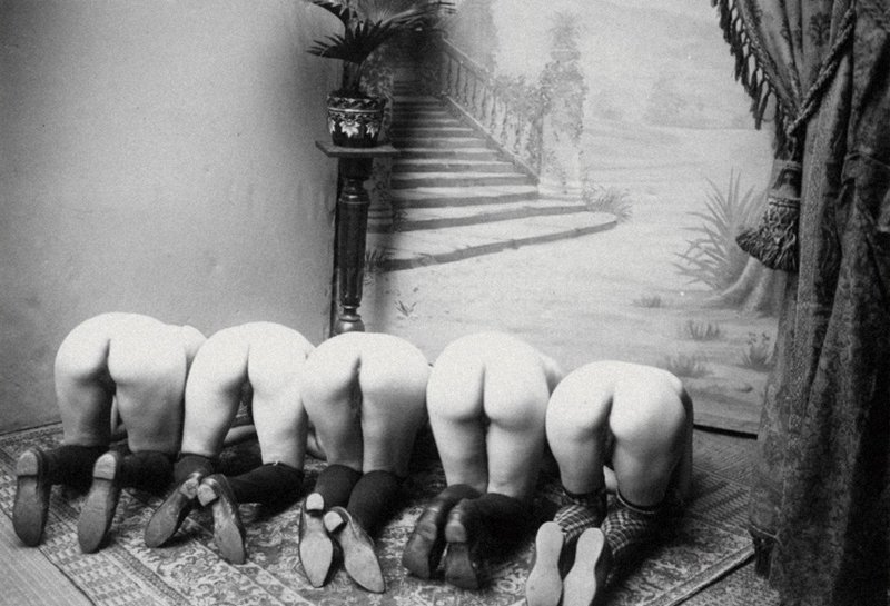 vintage photo of five bare bottoms bent over for spanking