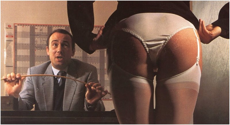 woman in fancy lingerie has rolled up her skirt and is preparing to bare her bottom for a punishment caning from a smirking man dressed like a businessman boss