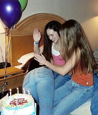 two girls giving a third her birthday spanking