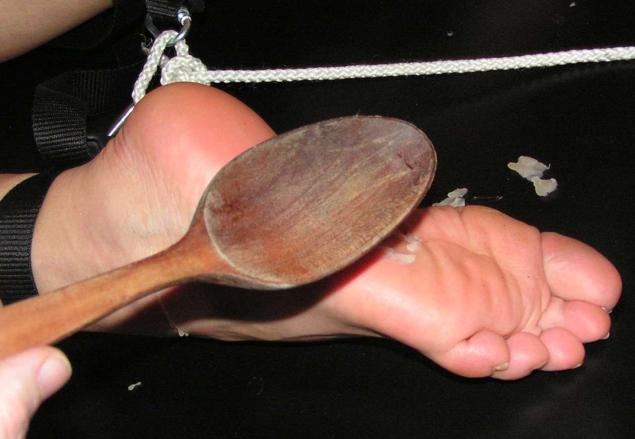 spanking her heat-tenderized feet with a wooden spoon to get the hot wax drippings off