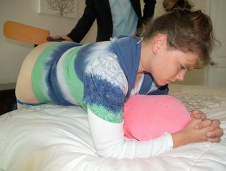pants down for a paddle spanking over the end of her own bed