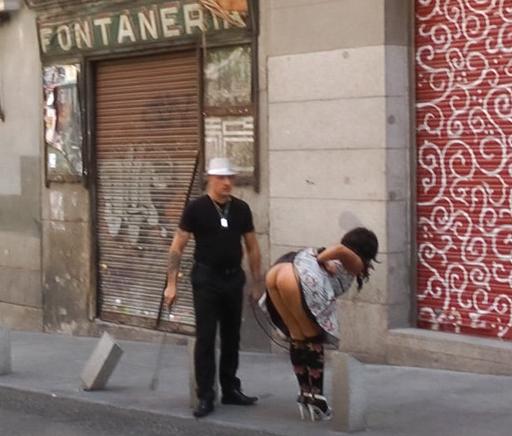 bent over for a riding crop spanking in the public street