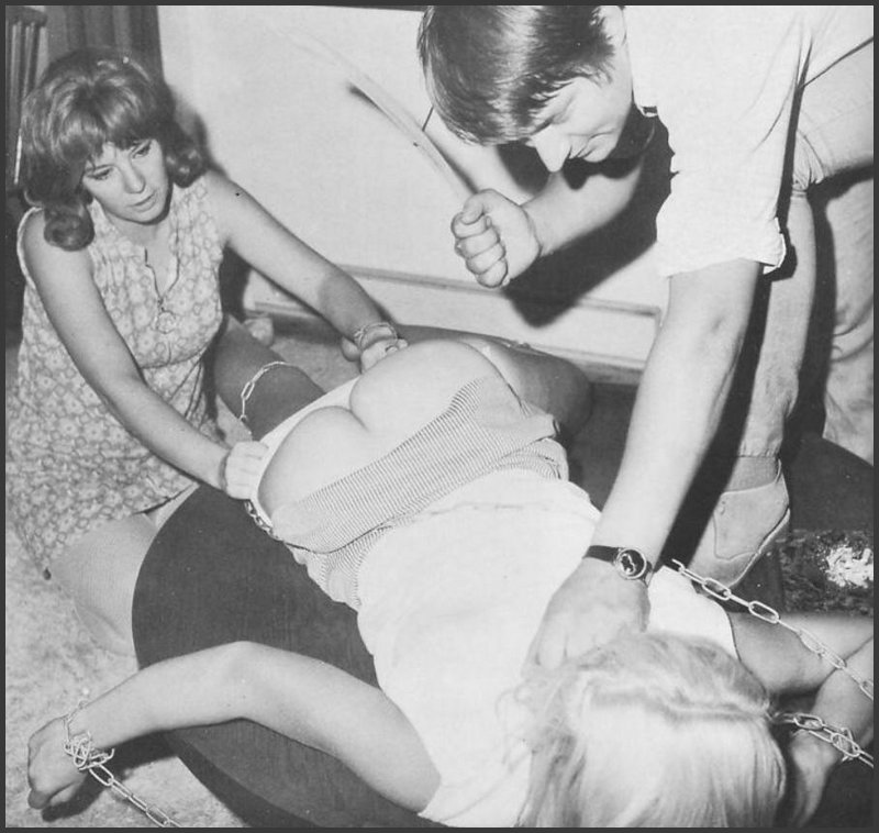 chained blonde being spanked with a wooden coat hanger