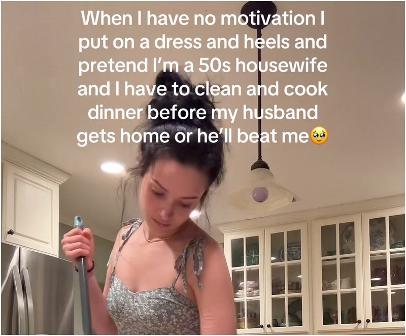 sweeping woman with a meme text caption saying when I have no motivation I put on a dress and heels and pretend I am a 50s housewife and have to clean and cook dinner before he gets home or he will beat me