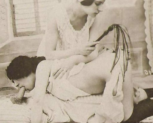 woman with a martinet whip supervises closely as two other people enjoy some mutual oral sex