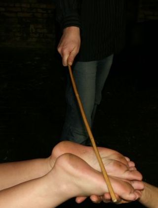 woman being caned on the soles of her feet